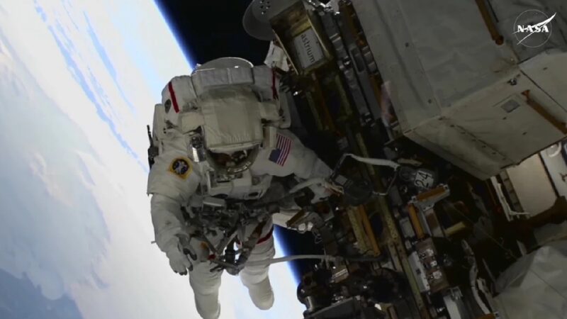 Stranded astronauts take first spacewalk, set record