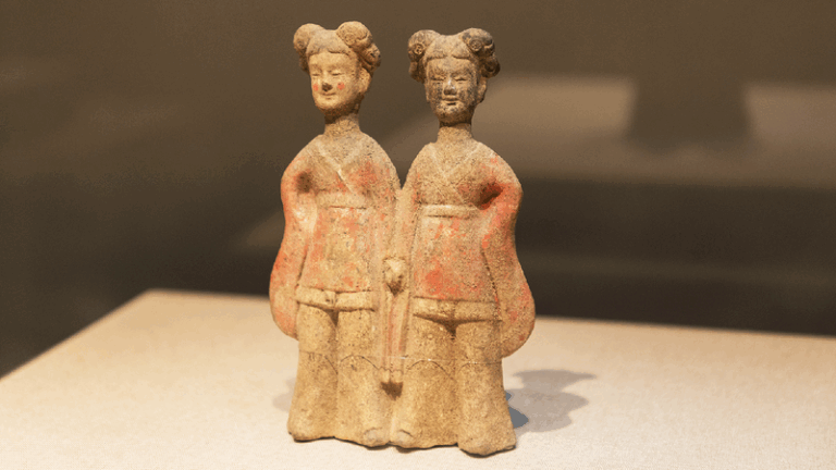 Ancient figurine of hand-in-hand women draws hanfu-clad duos